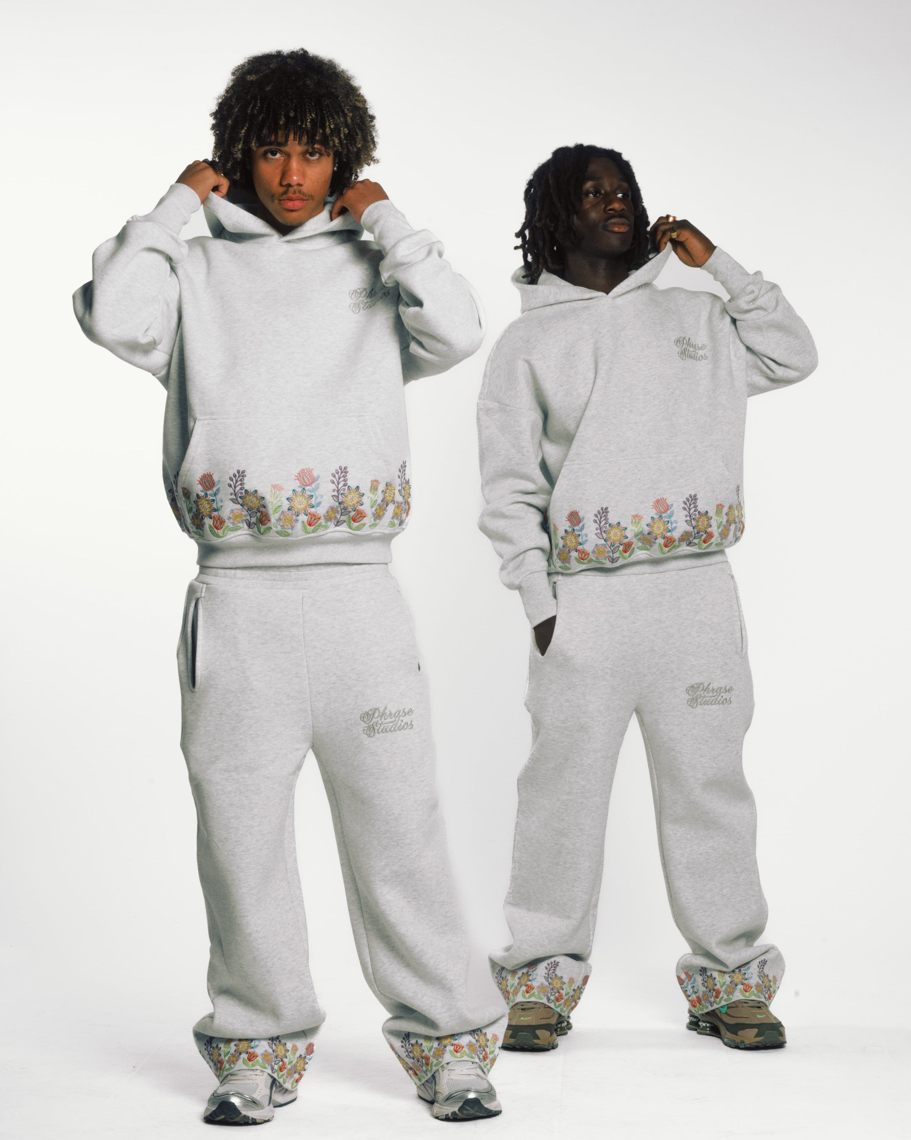 Men wearing Floral Tracksuit Unisex Hoodies and pants with floral embroidery, showcasing 100% cotton loungewear in a casual fit.