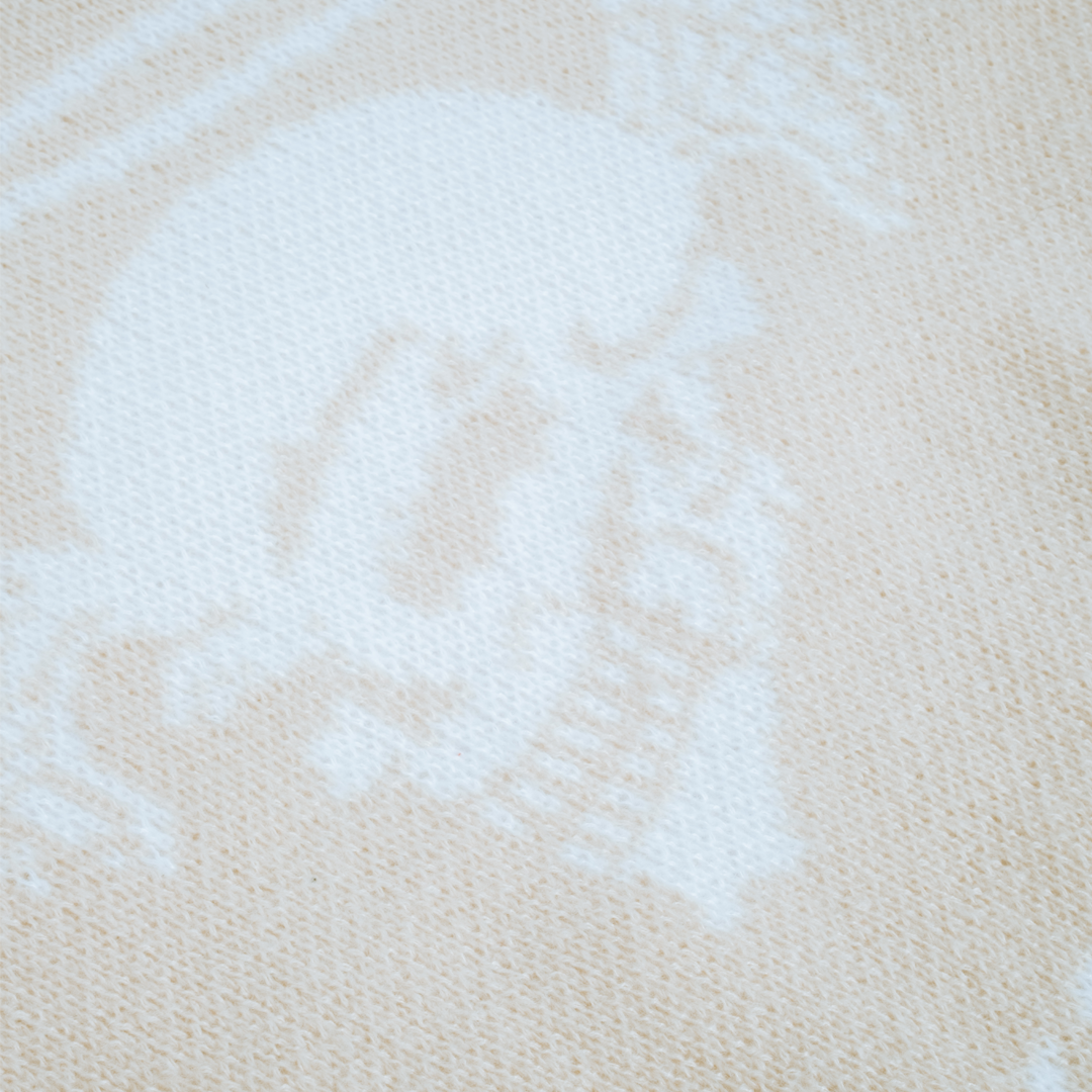 Close-up of distressed knit fabric with skull and angel design