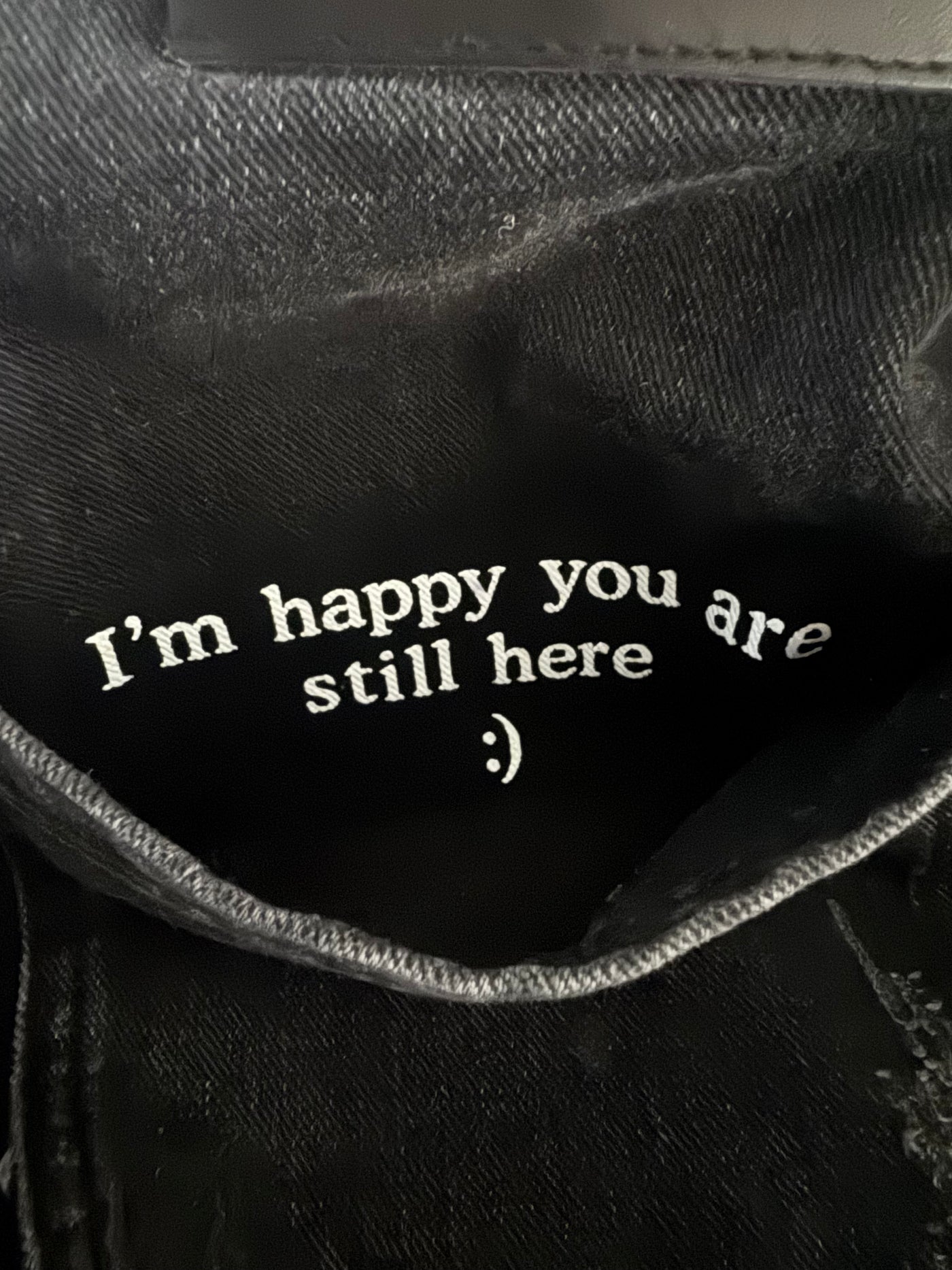 Black jeans with white embroidered message inside