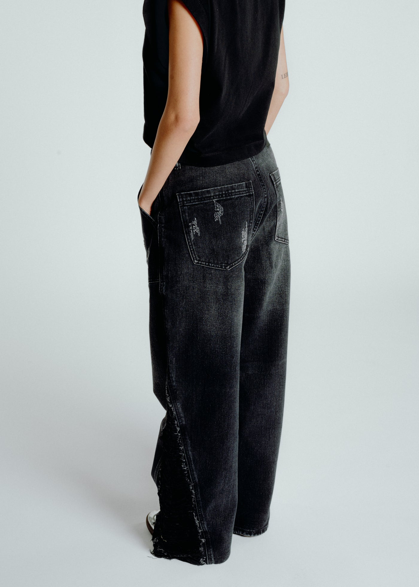 Black distressed jeans with frayed edges and worn-out details