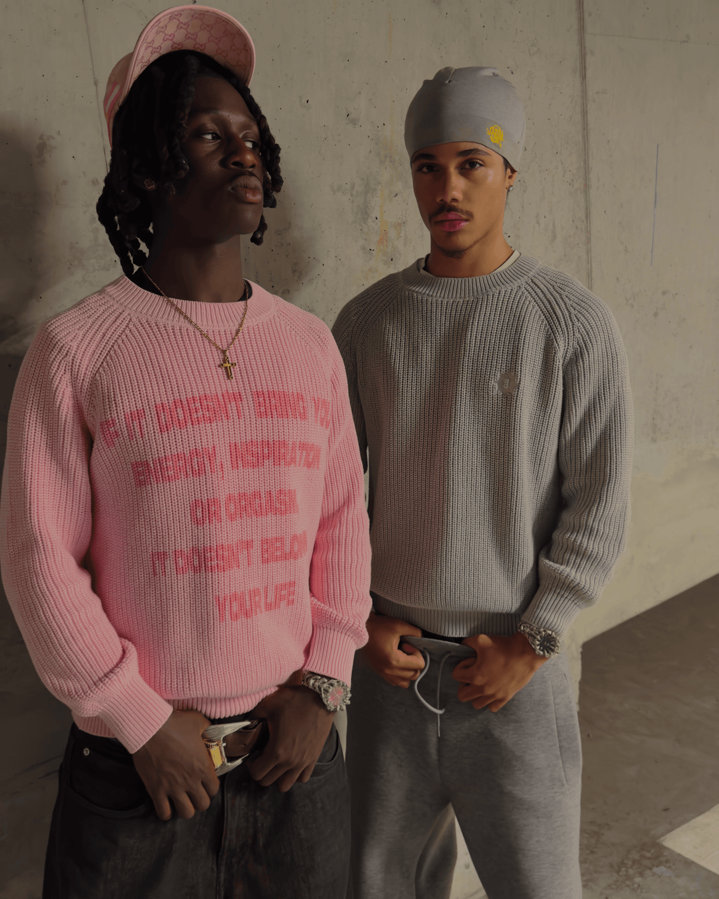Models in pink and gray Manifest Knit sweaters in urban setting