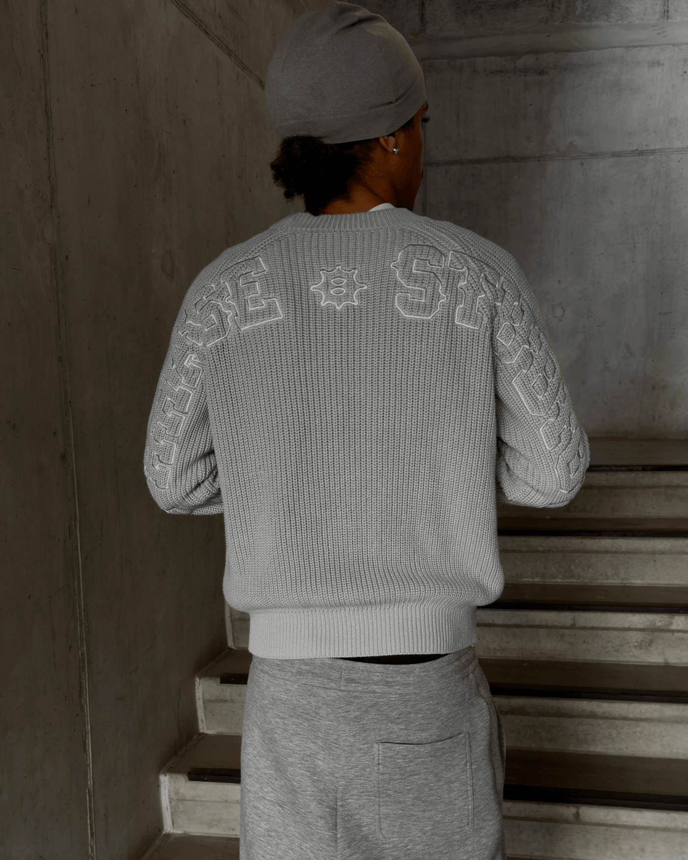 Model wearing Gray Horizon Knit sweater in casual streetwear style