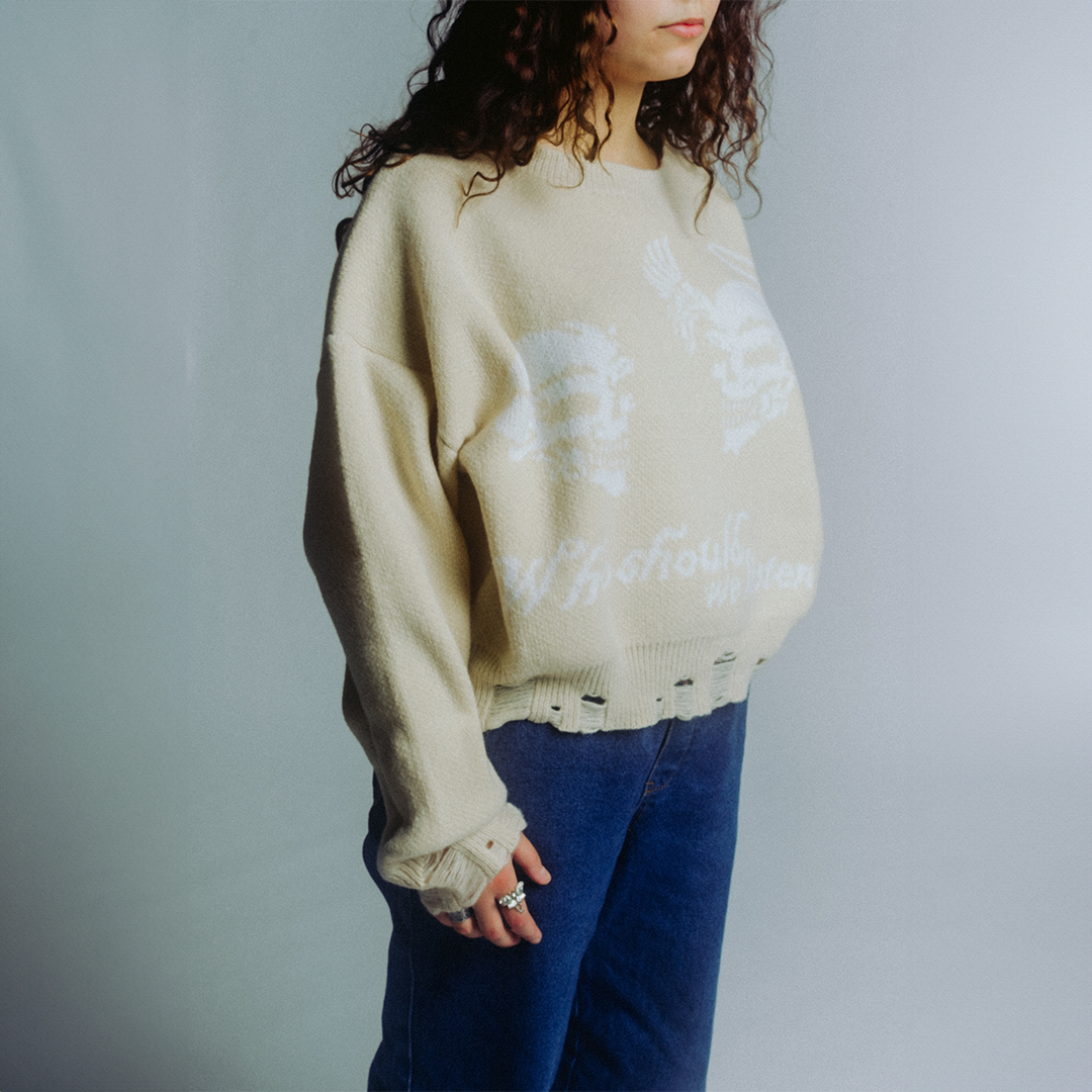 Beige oversized knit sweater with skeleton print and distressed hem
